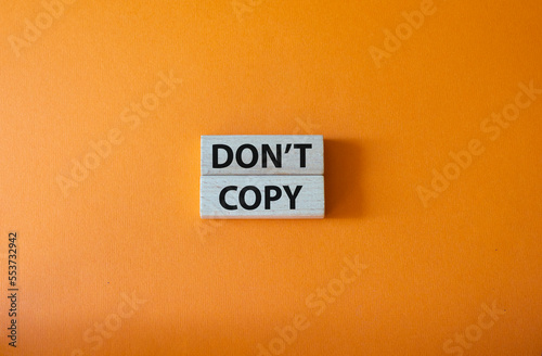 Don't copy symbol. Wooden blocks with words Don't copy. Beautiful orange background. Business and Don't copy concept. Copy space.