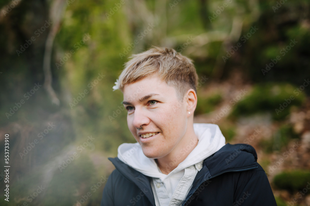 Smiling non-binary person looking away Smiling non-binary person looking away