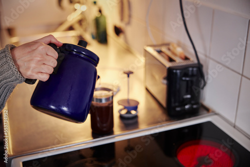 Woman preparing coffee in kitchen photo