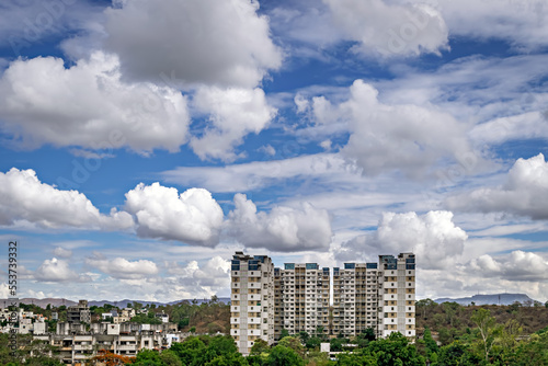 Tall housing building complex with nice blue sky and clouds background near the hill in Pune  Maharashtra.
