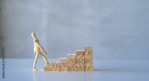 wooden man walking up the career ladder Wooden brick ladder, concept of self-improvement, career, transformation, success step. White background. copy space for ads