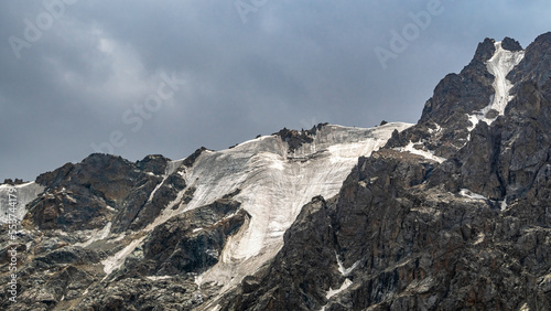 mountain peaks covered with snow. mountain glaciers. rocks in the snow. river permafrost