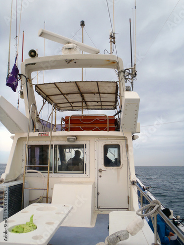 Wheelhouse  of the Japanese fishing boat. Cloudy calm sea photograph taken from the rear deck.
