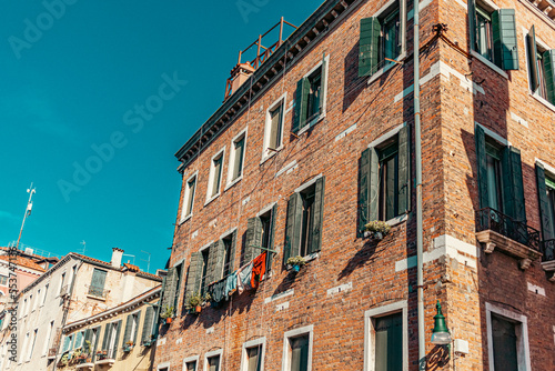 Detalhe das janelas com persianas verdes em Burano na Itália © Adriano