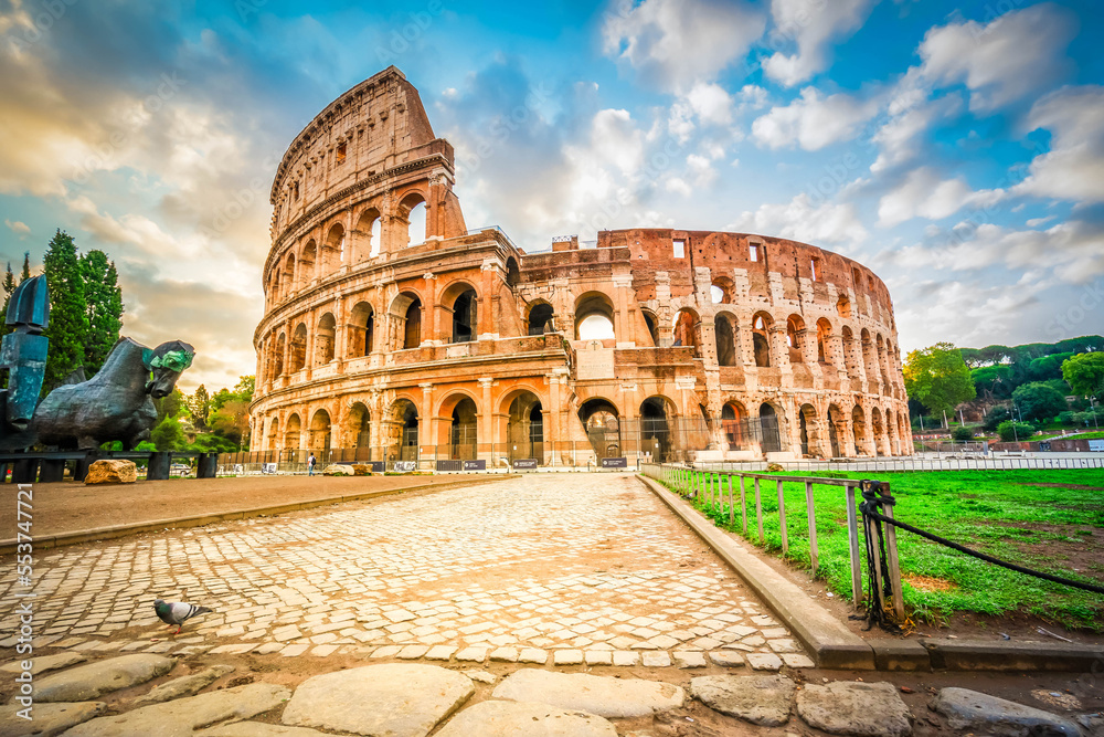ruins of antique Colosseum building with grass lawn, Rome Italy