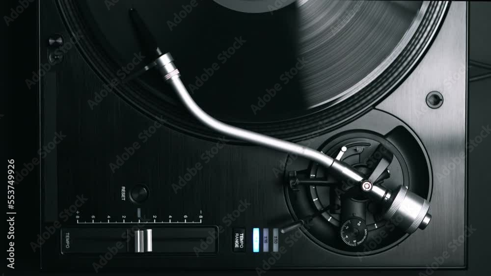 DJ turntable plays vinyl disc with music in vertical video. Flat lay footage of disc jockey record player