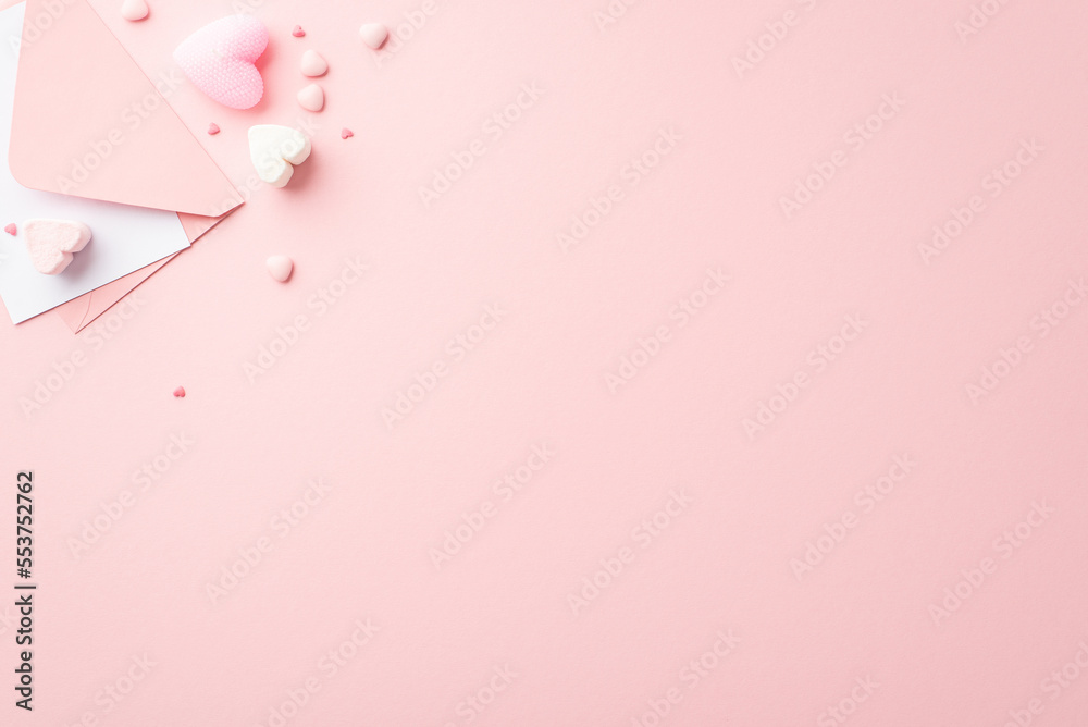 Saint Valentine's Day concept. Top view photo of envelope with letter heart shaped marshmallow and sprinkles on isolated pastel pink background with copyspace