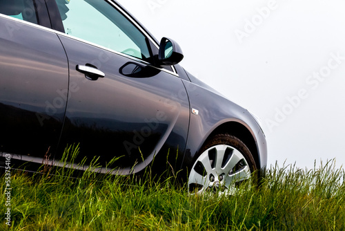 Brand new black car on green glass