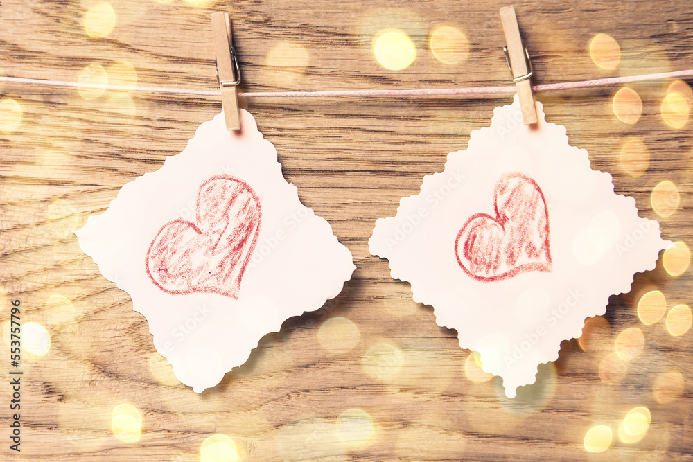 Love hearts on wooden texture background, valentines day card concept. beautiful bokeh effect from a garland.