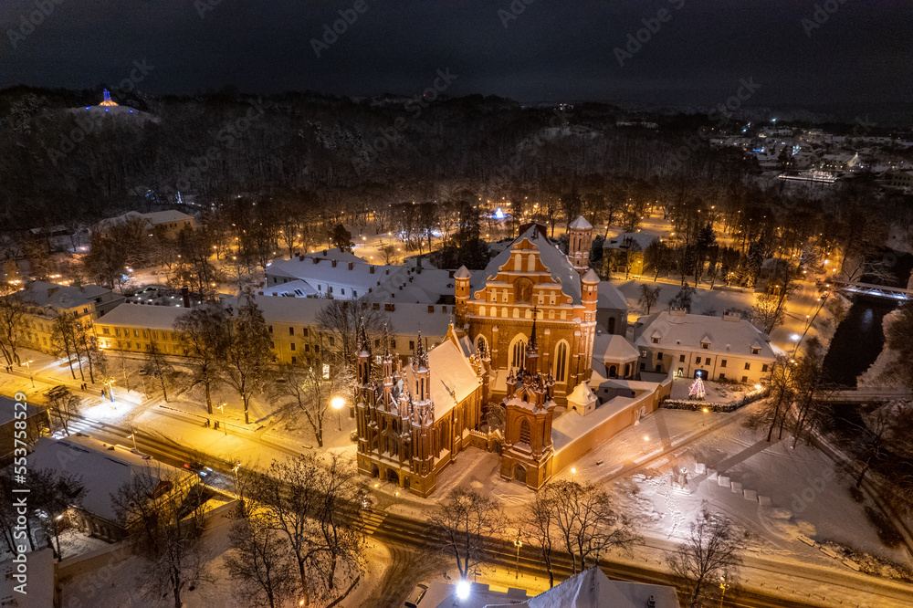Aerial winter snowy night view of St. Anne's Church (Onos baznycia) Vilnius old town, Lithuania
