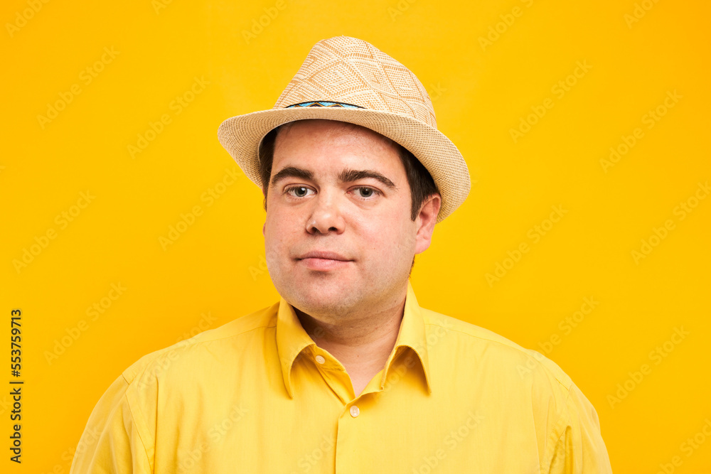 Portrait of positive fat man in hat kindly smiling isolated on yellow studio background, travel vacation concept Portrait of positive fat man in hat kindly smiling isolated on yellow studio background, travel vacation concept
