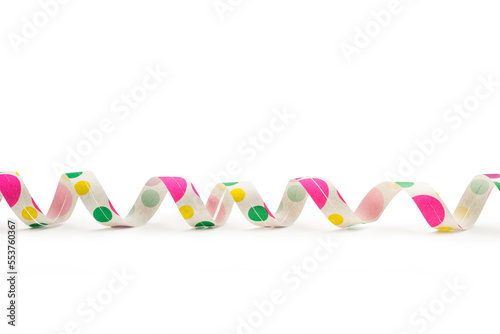 Guirnalda serpentina de papel con lunares de colores sobre un fondo blanco liso y aislado. Vista de frente y de cerca. Copy space. photo