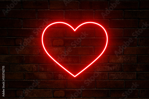 Neonowe serce z blaskiem na tle ciemnej ceglanej ściany. Neonowy znak.