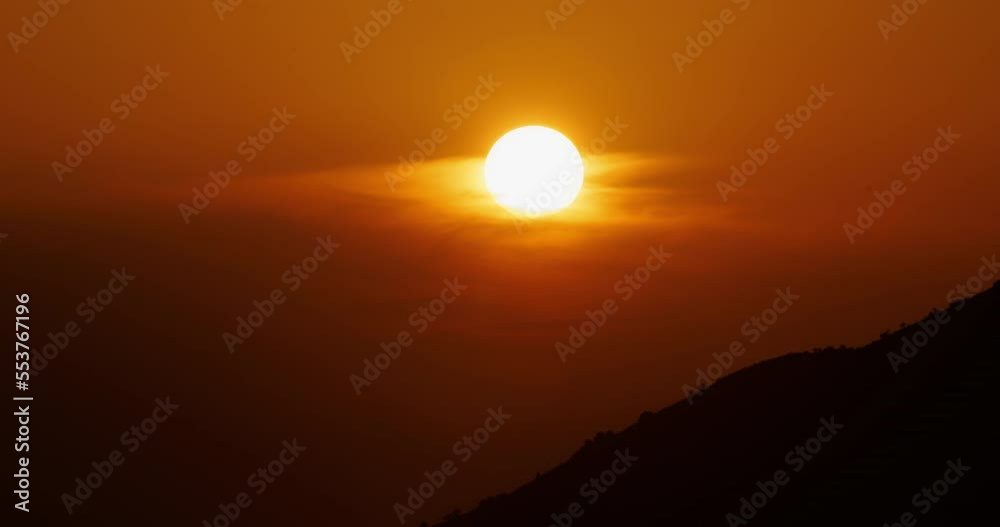big sun sunset timelapse and cloudless sky, majestic Big Red Hot Sun in mountainous area, the end of something concept, golden hour telephoto lens shot big sun sunset timelapse and cloudless sky, majestic Big Red Hot Sun in mountainous area, the end of something concept, golden hour telephoto lens shot
