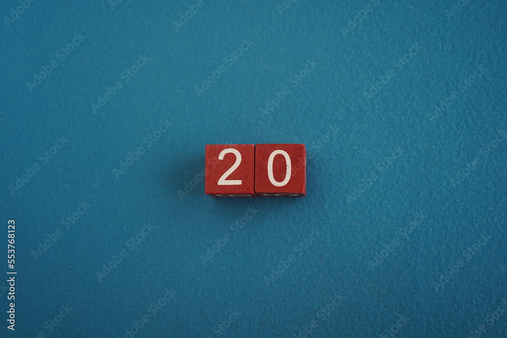 Wooden Viva Magenta cubes with number 20 on blue background close-up top view. Concept of date or time. White numbers 20 on red cubes velvet backdrop. Copy space for text or event. Blurred background Wooden Viva Magenta cubes with number 20 on blue background close-up top view. Concept of date or time. White numbers 20 on red cubes velvet backdrop. Copy space for text or event. Blurred background
