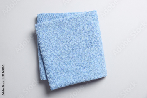 Soft folded light blue towel on light grey background, top view