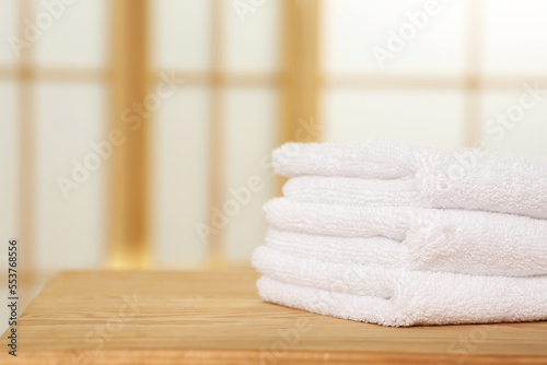 Soft folded terry towels on wooden table indoors, space for text