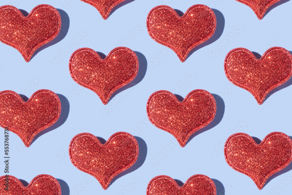 Pattern made from glitter heart shape on colored background with hard shadow. Valentines day minimalistic design