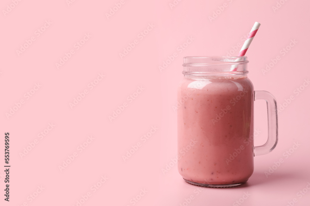 Mason jar with delicious berry smoothie on pink background. Space for text Mason jar with delicious berry smoothie on pink background. Space for text