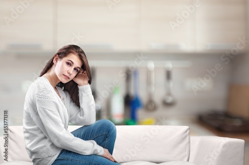 Sad alone young woman thinking at home