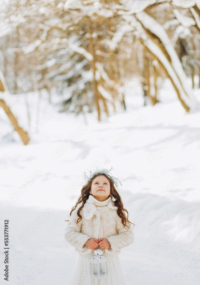 A little girl walks in a snowy park. A little girl walks in a snowy park.