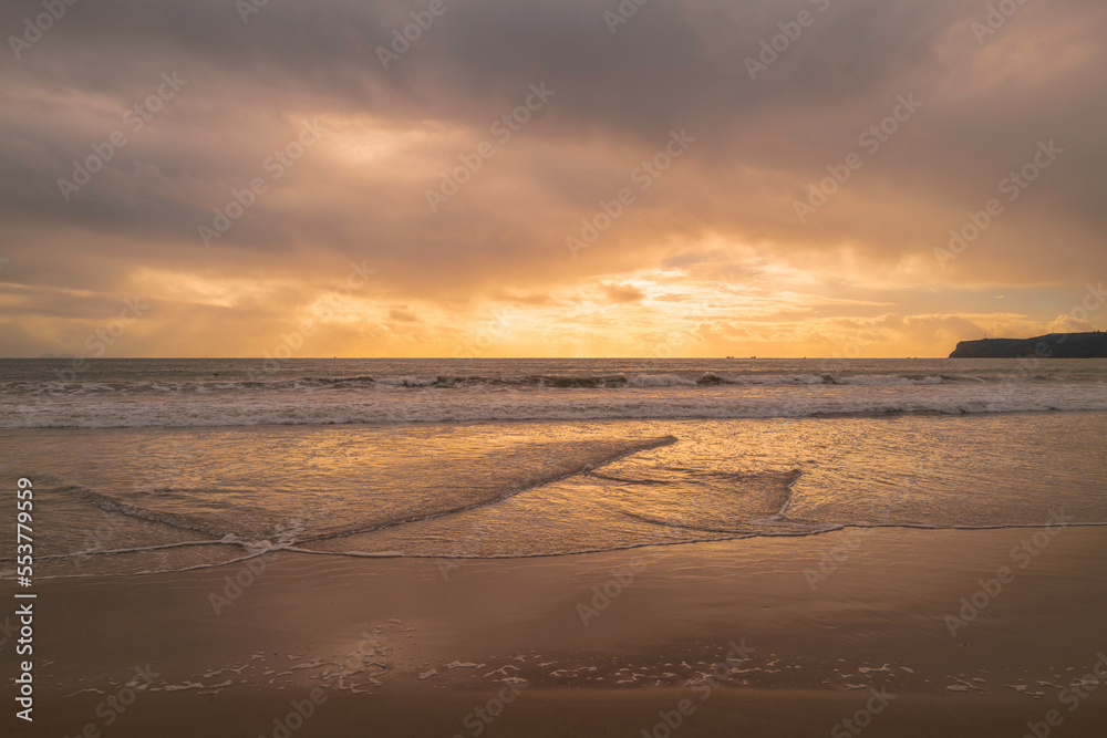 Sunset on the Coronado Beach Series with dramatic cloudscape, rolling waves, and wet reflection on the sand in San Diego, California, USA, tranquil seascape backgrounds