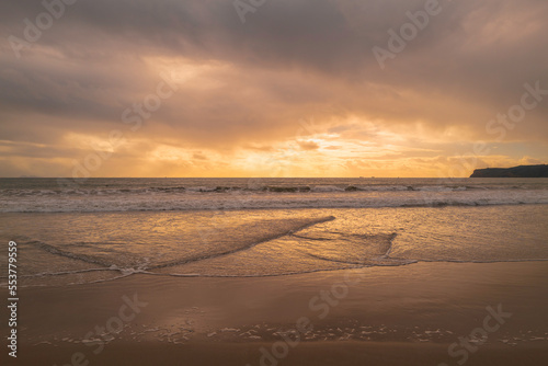 Sunset on the Coronado Beach Series with dramatic cloudscape  rolling waves  and wet reflection on the sand in San Diego  California  USA  tranquil seascape backgrounds