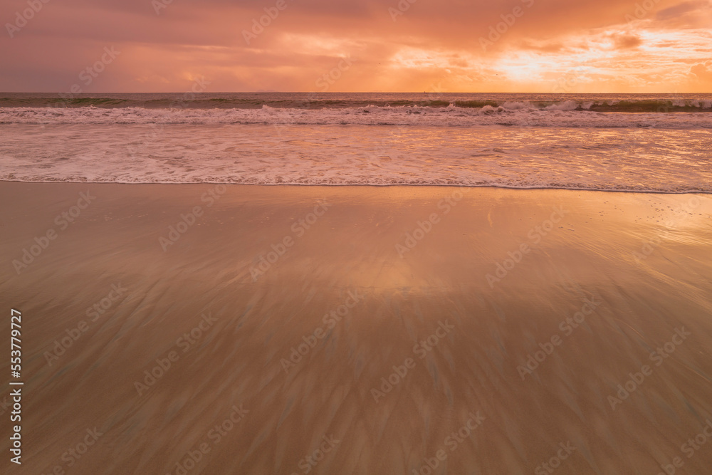 Sunset on the Coronado Beach Series with dramatic cloudscape, rolling waves, and wet reflection on the sand in San Diego, California, USA, tranquil seascape backgrounds