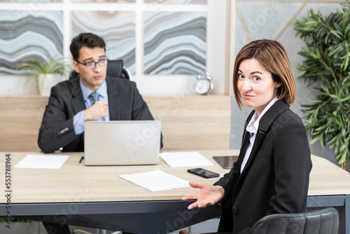 Confused woman in suit feeling stress on interview in the office 