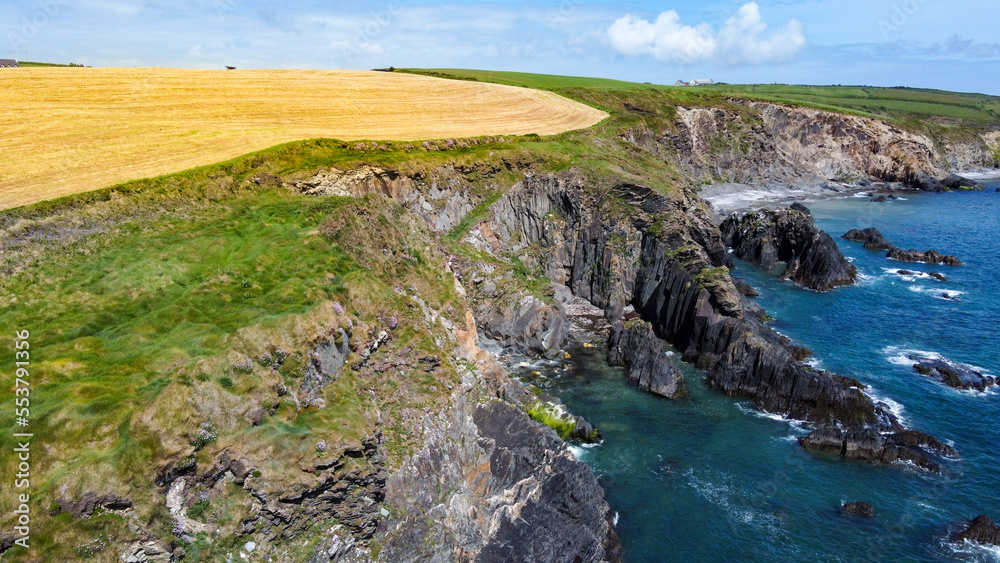 Farm fields on the shore of the Celtic Sea, south of Ireland, County Cork. Beautiful coastal area. Turquoise waters of the Atlantic. Picturesque stone hills. Drone point of view. Farm fields on the shore of the Celtic Sea, south of Ireland, County Cork. Beautiful coastal area. Turquoise waters of the Atlantic. Picturesque stone hills. Drone point of view.