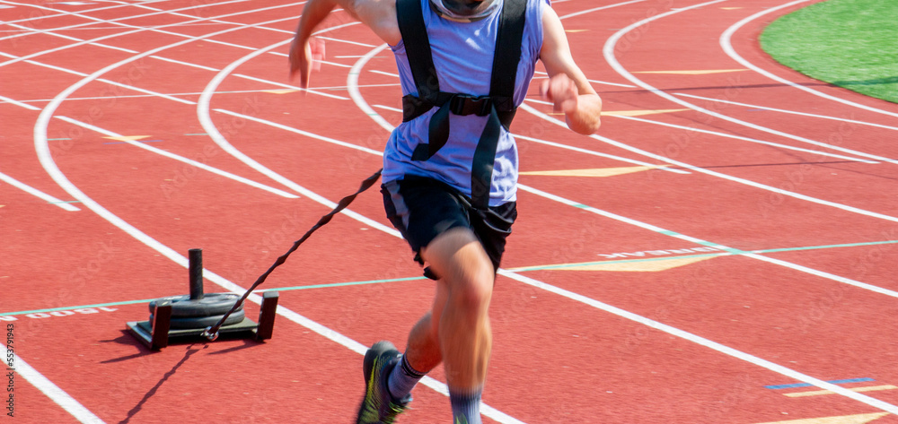 Runner pulling a sled with weights on a track