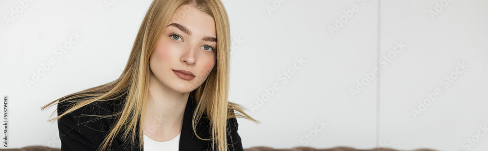 Naklejka premium Young blonde woman in jacket looking at camera at home, banner.