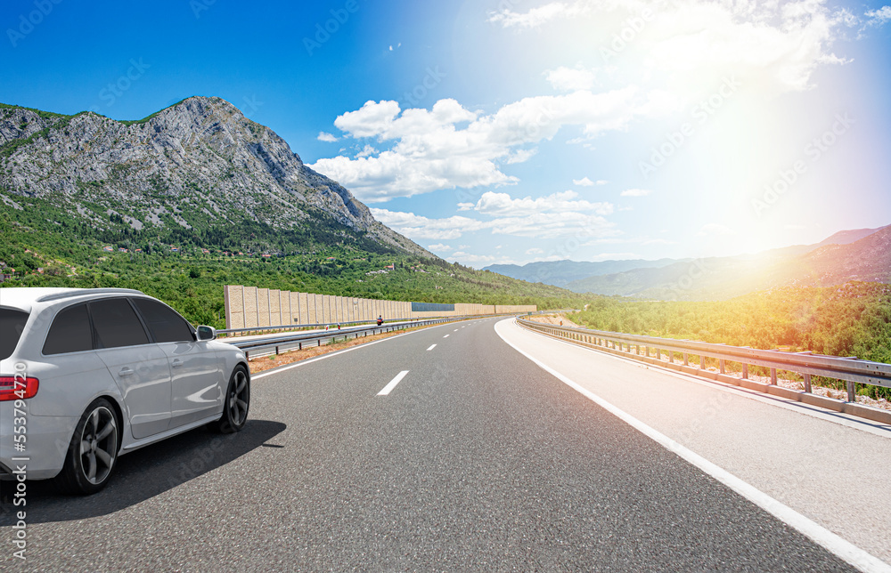 Picturesque road in the mountains and a white car.