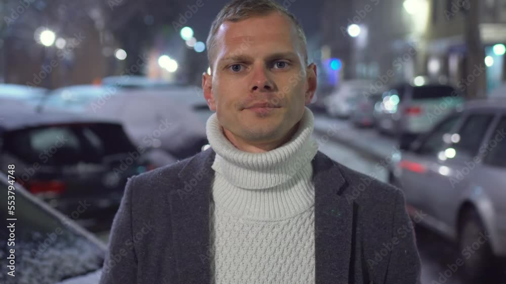 Portrait of young business man posing at dark after work in office. Closeup gorgeous man face looking at camera outdoors under snowfall at winter night. Successful people concept Portrait of young business man posing at dark after work in office. Closeup gorgeous man face looking at camera outdoors under snowfall at winter night. Successful people concept