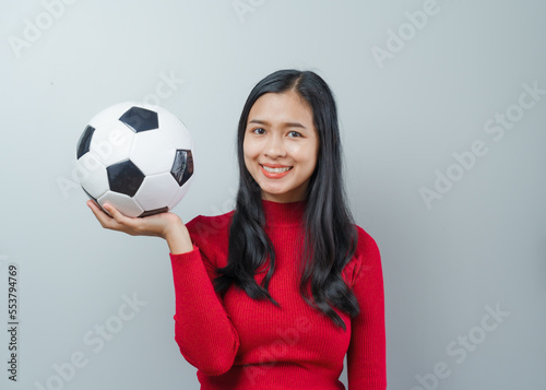 Asian attractive woman soccer sports fans in red sweater isolated over background. © NanSan