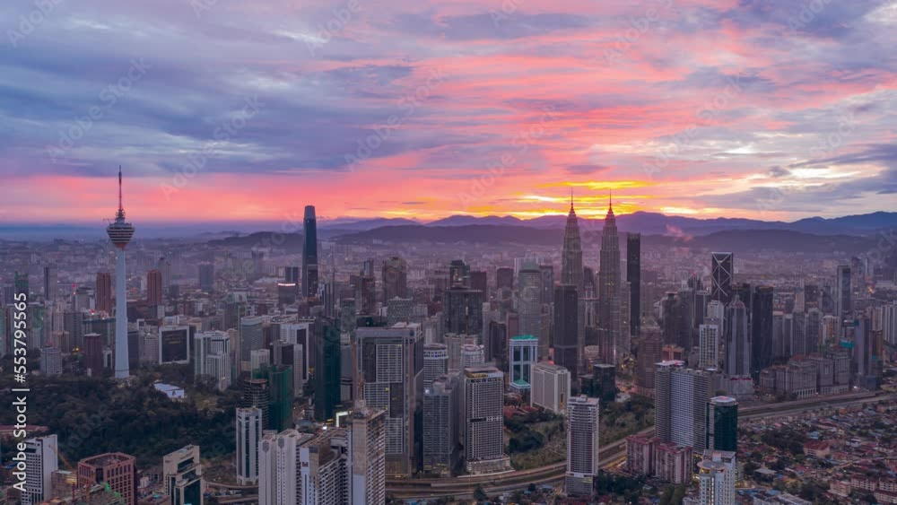 Aerial Drone Time lapse: Kuala Lumpur city view during dawn overlooking the city skyline with busy city streets in Federal Territory, Malaysia. Prores 4KUHD Timelapse.