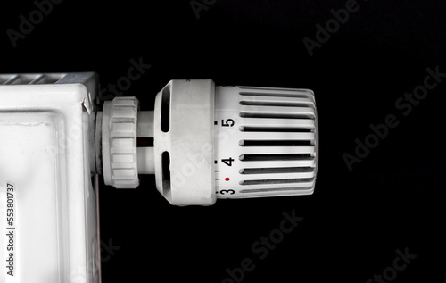 Thermostatic radiator valve head and heater close up, adjusting temperature, energy crisis and increasing heating costs in Europe concept