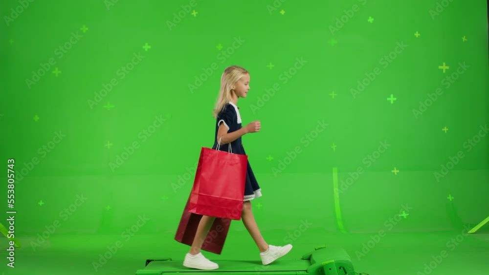 Young girl in casual clothes walking with shopping bags on a Green Screen, Sale day. Woman buyer on Chroma Key. 4k UHD side view video Young girl in casual clothes walking with shopping bags on a Green Screen, Sale day. Woman buyer on Chroma Key. 4k UHD side view video