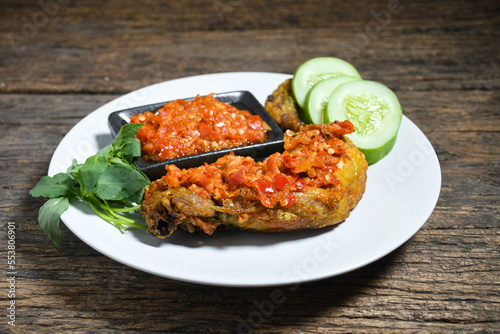 Ayam geprek sambal indonesian food or geprek fried chicken with sambal hot chili sauce. Selective Focus