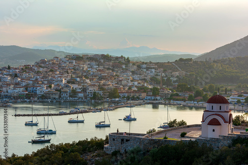 Beautiful view of Ermioni sea lagoon with moored yachts and boats at sunset time.