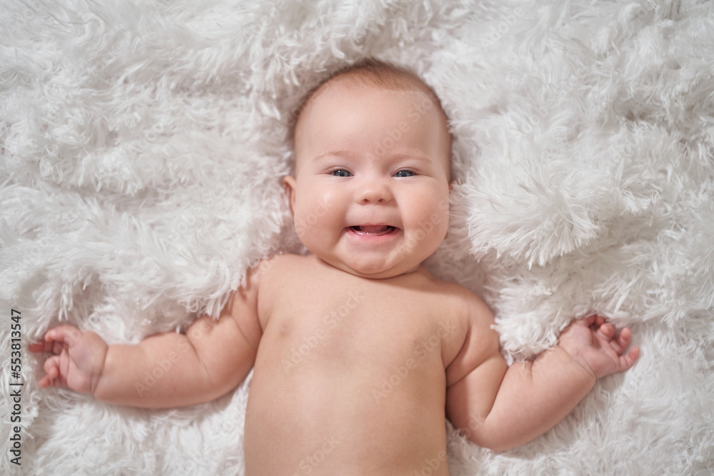 the baby lies on his back on a soft comforter the baby lies on his back on a soft comforter