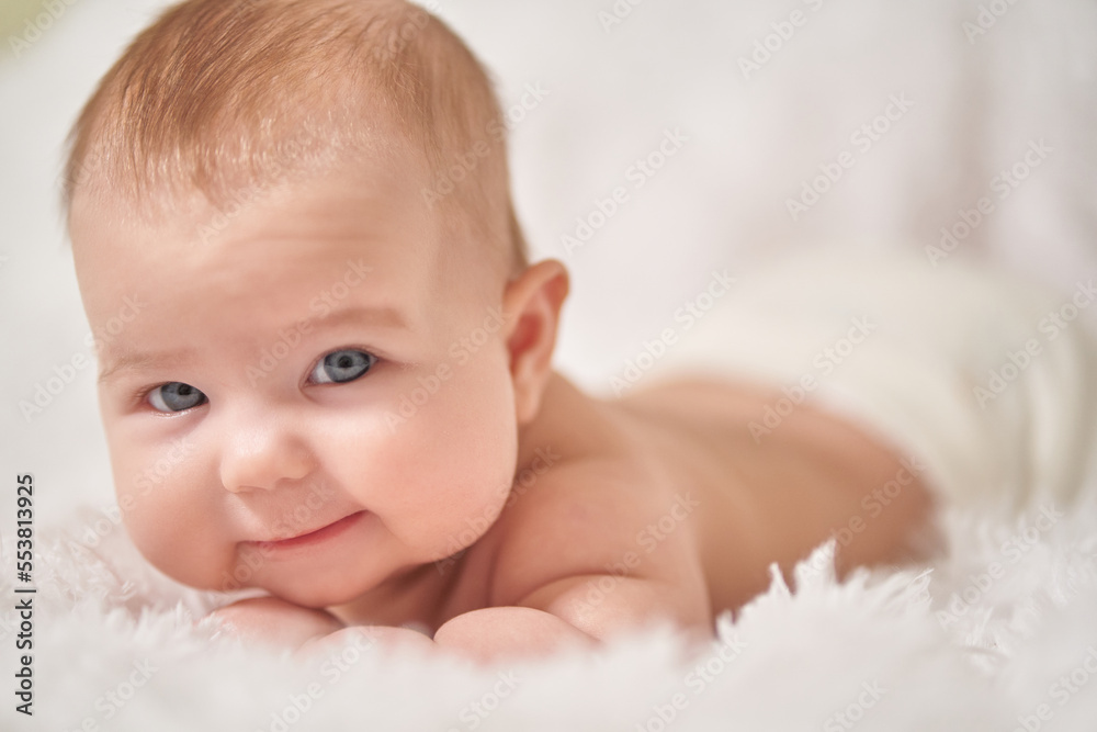 portrait of a smiling baby looking into the camera on a soft blanket portrait of a smiling baby looking into the camera on a soft blanket