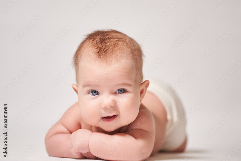 portrait of an infant looking at the camera with an amused grimace portrait of an infant looking at the camera with an amused grimace