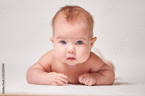 the wary look of an infant staring into the camera against a bright background