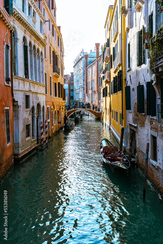 Venice, its characteristic architecture. View of an internal canal, with the docking of boats and gondolas.