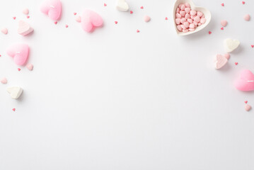 Saint Valentine's Day concept. Top view photo of heart shaped marshmallow pink candles and saucer with sprinkles on isolated white background with copyspace