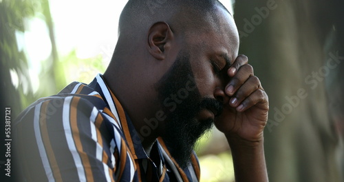 Fotografie Preoccupied black man feeling worry and angst praying seeking help-1