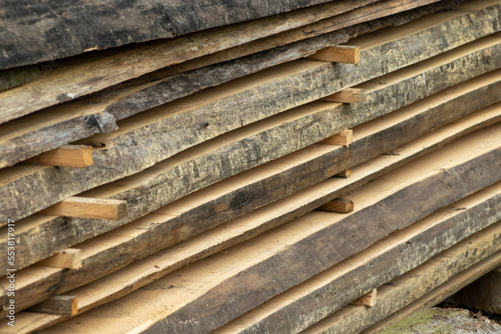 Piled lumber near a lumber mill. Lumber and wood slice. Stacked lumber. Folded wood.Closeup wood board
