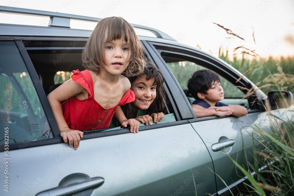 three girls watching from family car windows