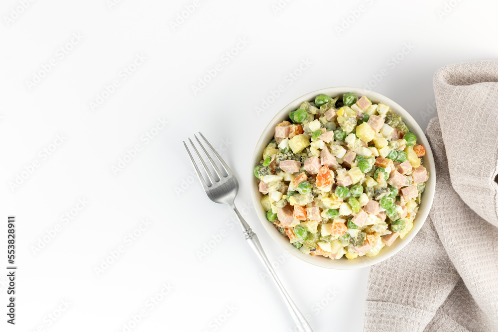 Russian Olivier salad. Russian New Year salad of vegetables, sausage and on a gray background, top view. Russian cuisine Russian Olivier salad. Russian New Year salad of vegetables, sausage and on a gray background, top view. Russian cuisine